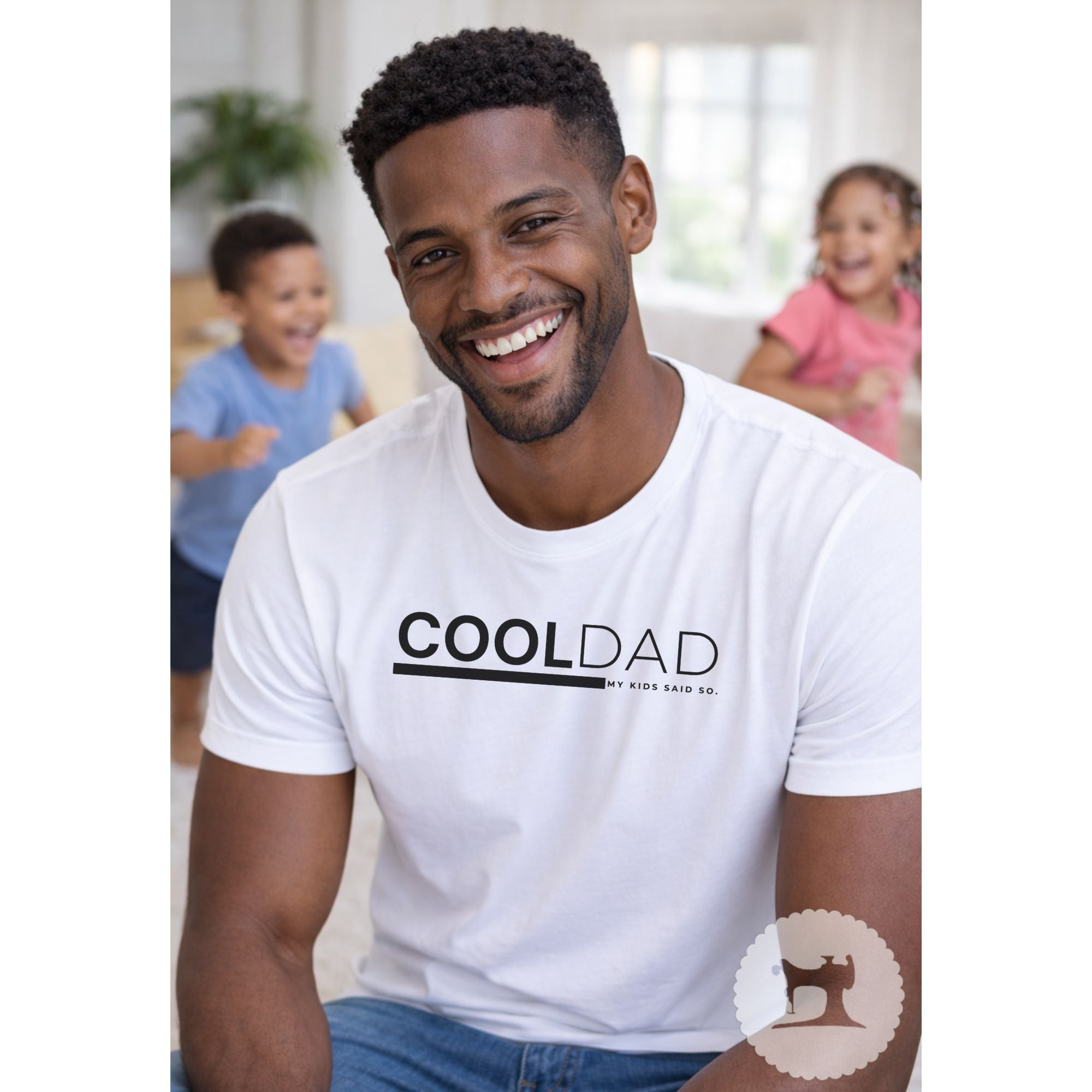 Man wearing a white t-shirt with 'COOL DAD' text, smiling with children in the background.