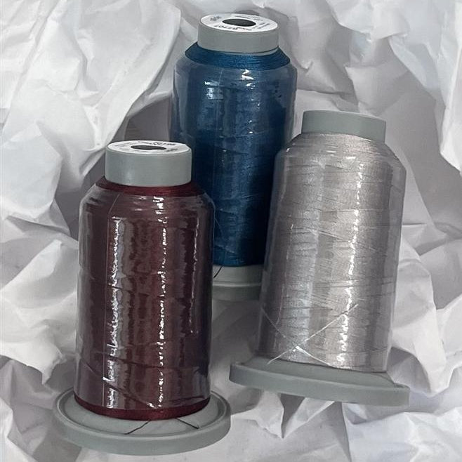 Three spools of thread in different colors on a white background