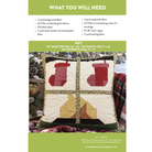A quilting pattern cover page titled 'WHAT YOU WILL NEED' with fabric lists and a key showing measurements for a quilted pillow. The center shows two coordinated pillows with stocking and geometric quilted designs, placed on a plaid blanket with pinecones and greenery.