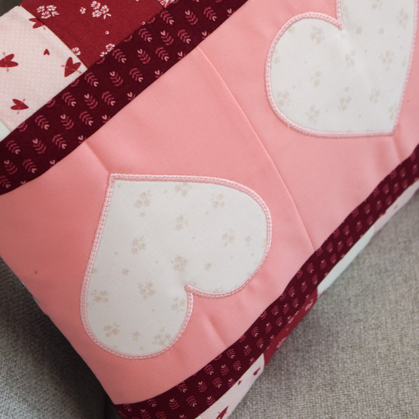 Quilt with heart patterns on a gray surface