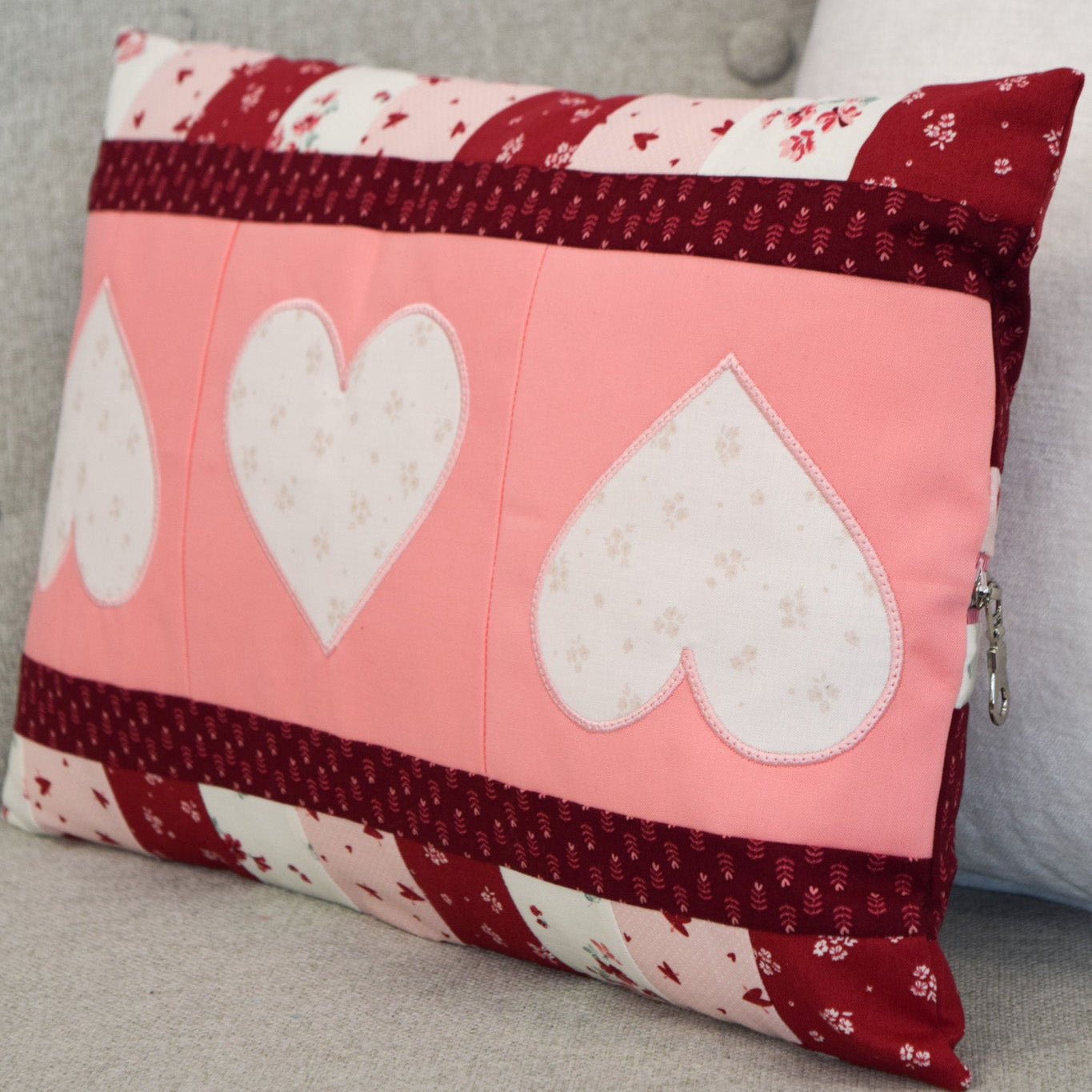 Decorative pillow with heart patterns on a gray surface
