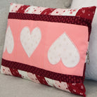Decorative pillow with heart patterns on a gray surface