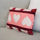 Decorative pillow with heart patterns on a gray couch