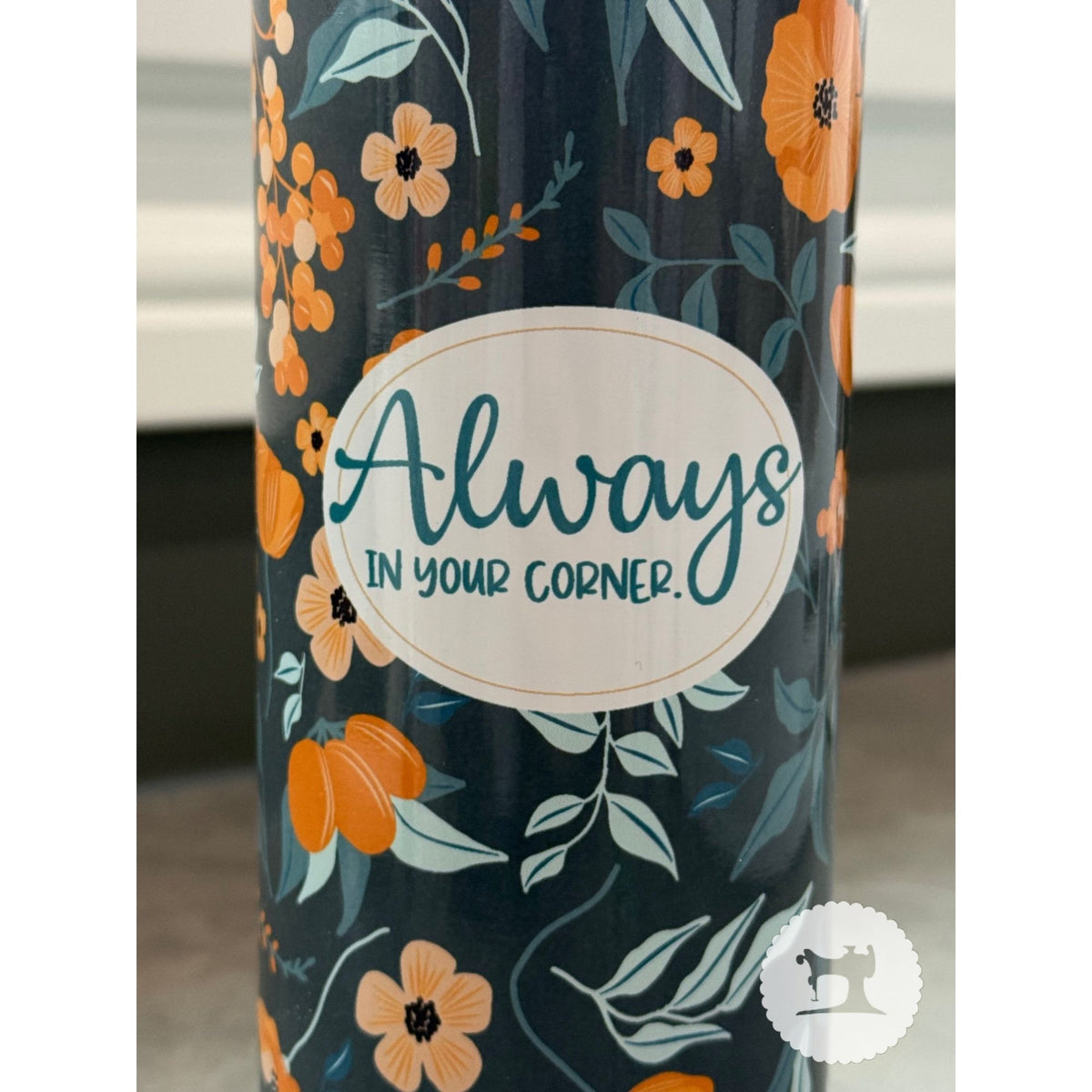 Tumbler with floral design and 'Always In Your Corner' text on a dark background