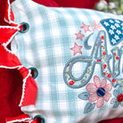 Decorative pillow with floral and letter 'A' design on a red background