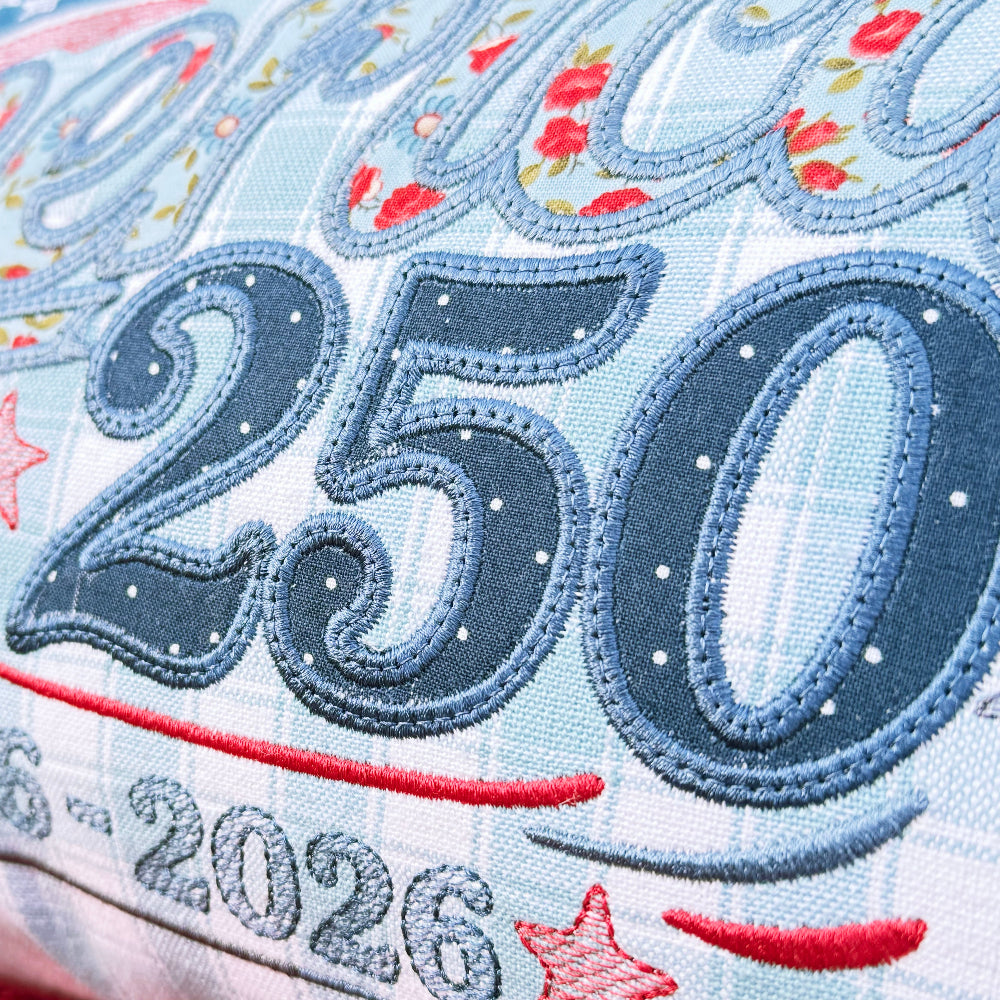 Textile item with '250' and '1776-2026' embroidery on a blue background