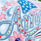 Embroidered fabric with floral and star designs, featuring the name 'Amelia'.