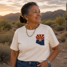 Woman wearing a white t-shirt with a desert landscape and cactus in the background