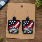 Pair of earrings on a brown card with a wooden background