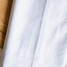 Close-up of white fabric with a wooden surface in the background