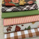 Collection of fall-themed fabric swatches on a wooden surface