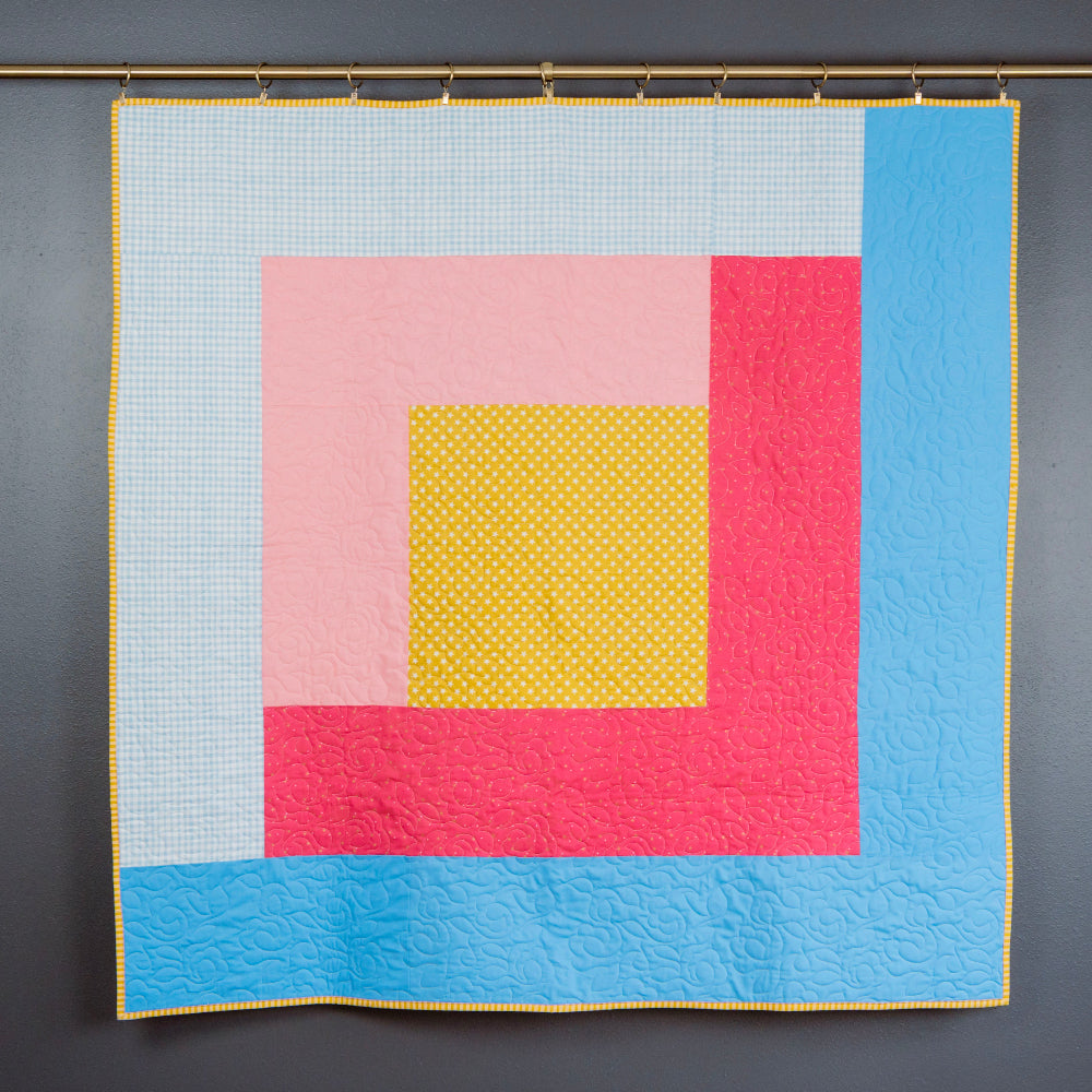 Colorful quilt with geometric pattern on a dark gray background