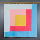 Colorful quilt with geometric pattern on a dark gray background