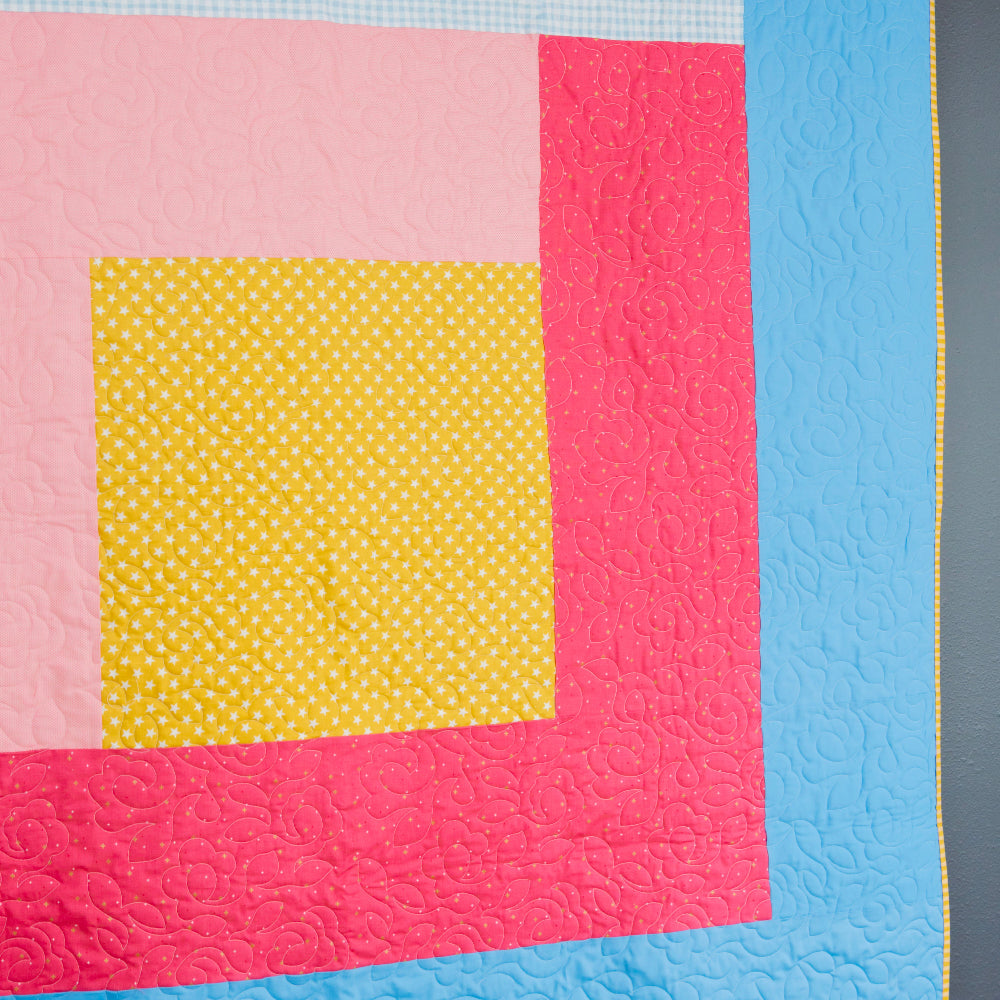 Quilt with colorful square patterns on a blue background