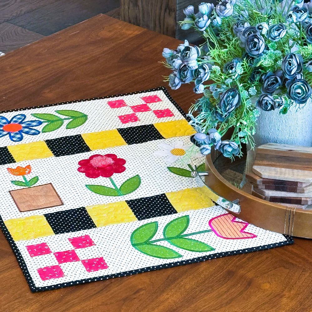 Colorful quilt with floral patterns on a wooden floor