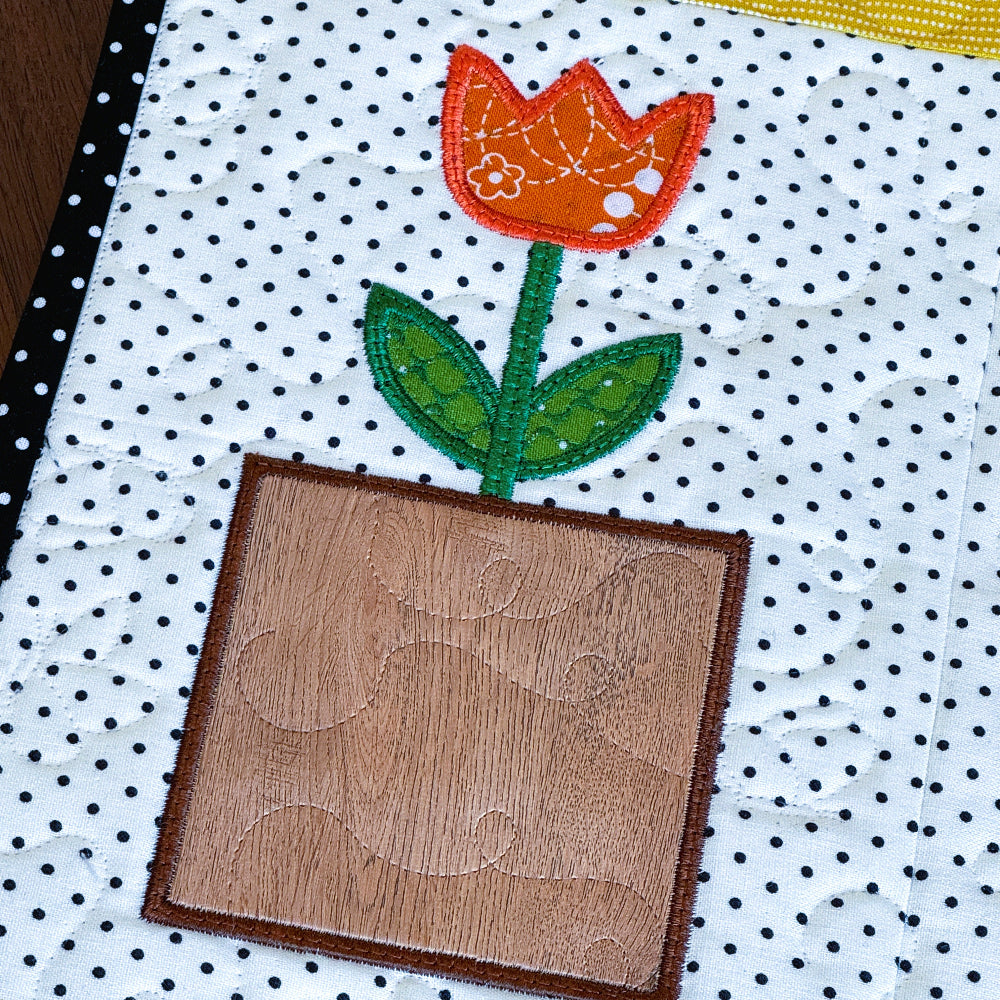 Patchwork quilt with a tulip design on a polka dot background