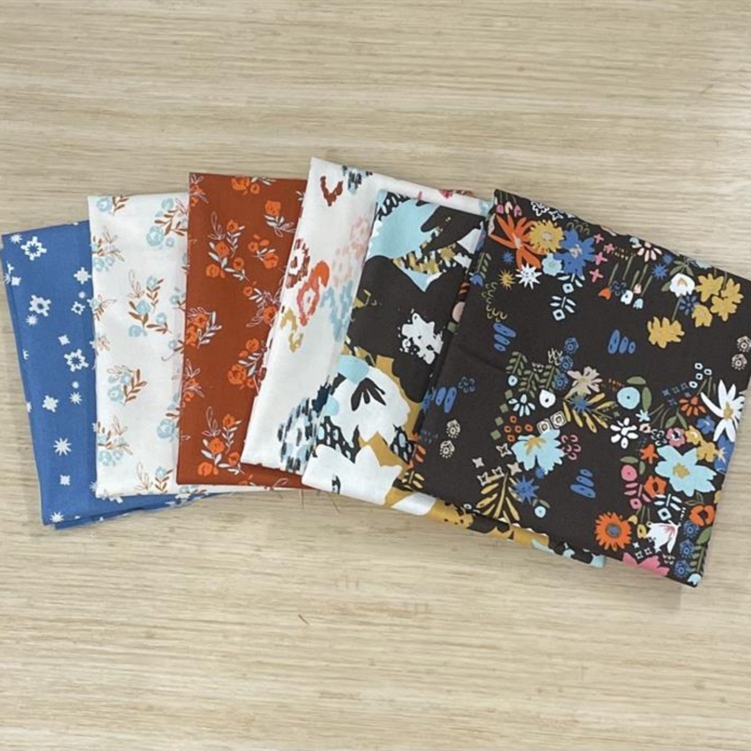 Set of six fabric swatches with various patterns on a wooden surface