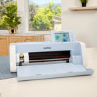 Brother cutting machine on a table with a window view of greenery