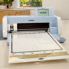 Brother cutting machine on a table with a window and plants in the background
