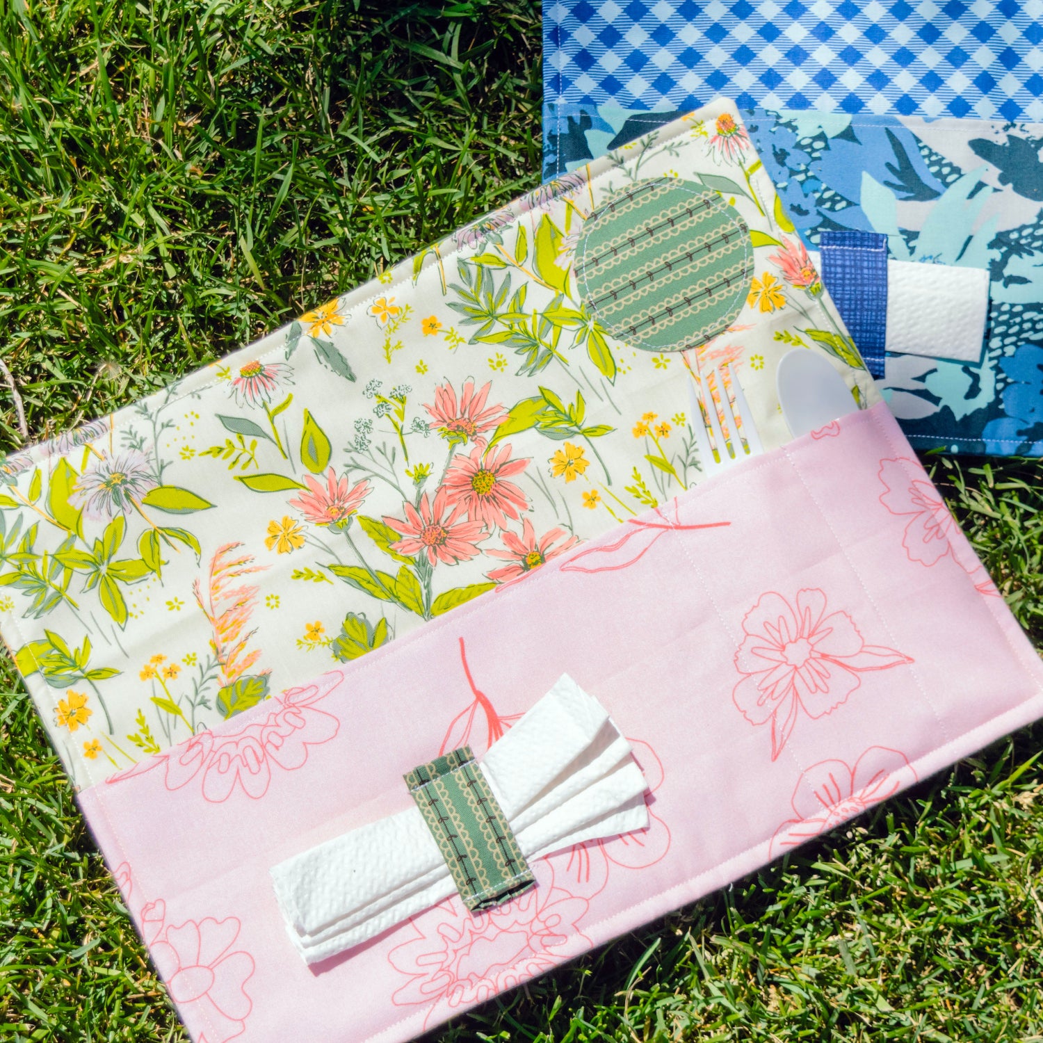 Floral and checkered fabric samples on grass