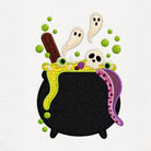A Halloween-themed embroidered design featuring a black cauldron with green slime, white ghosts, a skull, green bubbles, and a purple tongue, shown on a white textured background.