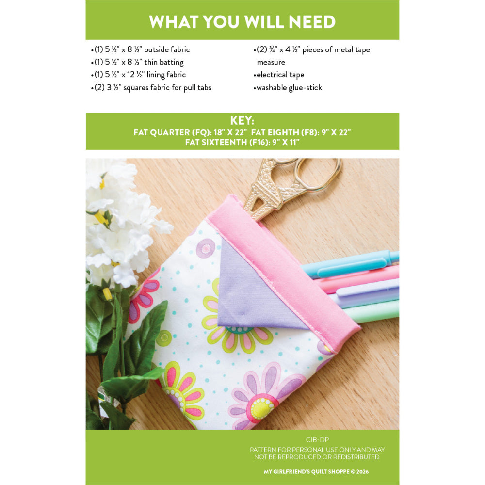 Fabric and materials list for a craft project with a colorful fabric item on a wooden surface.