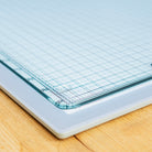 Grid-lined paper on a cutting mat with a wooden surface underneath