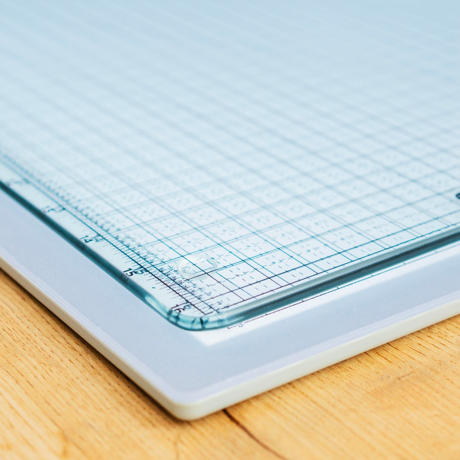 Grid-lined paper on a cutting mat with a wooden surface underneath