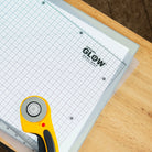 Grid cutting mat with rotary cutter on a wooden surface