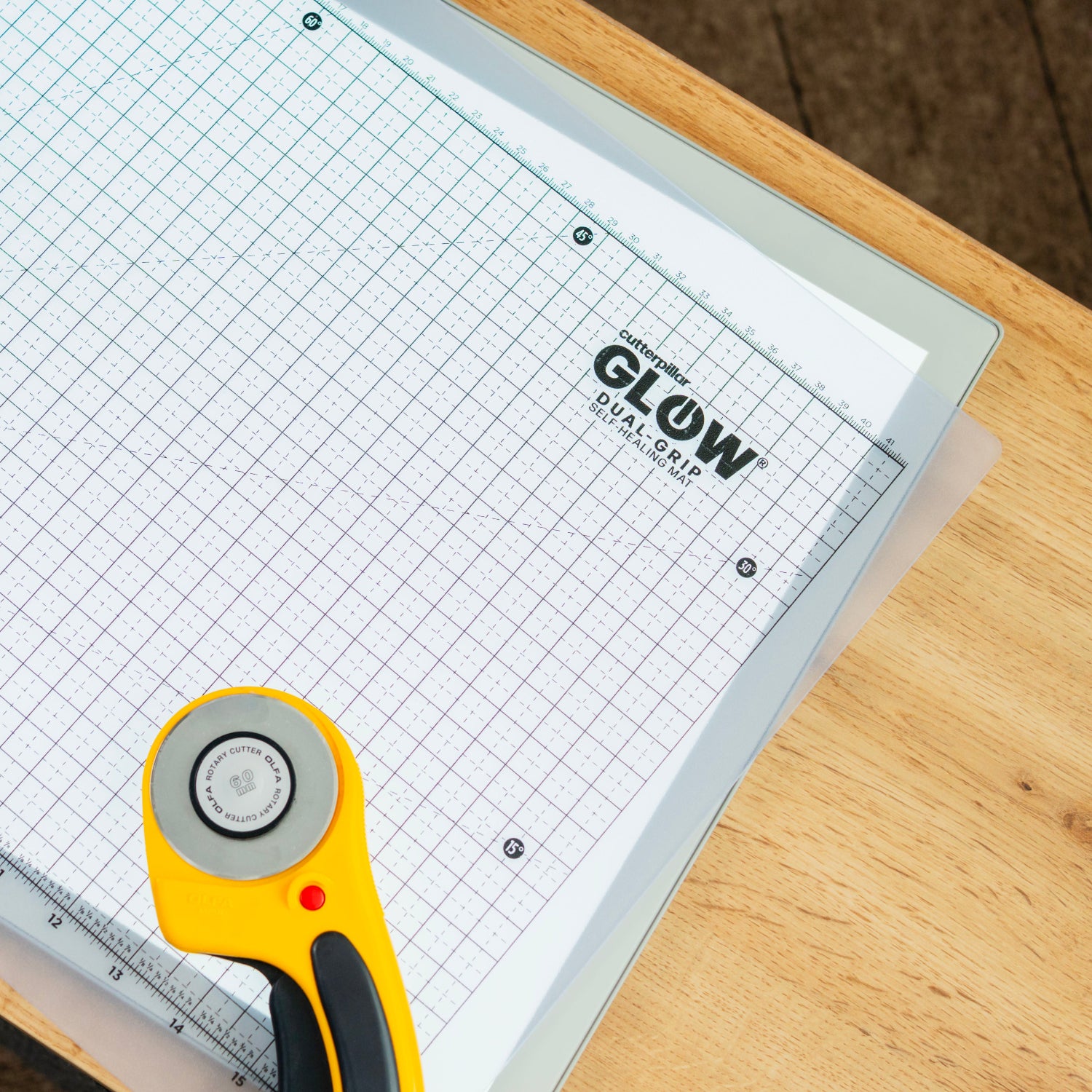 Grid cutting mat with rotary cutter on a wooden surface