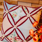Decorative pillow with floral patterns and button details on a wooden surface.