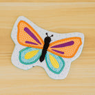 Colorful butterfly-shaped patch on a wooden surface