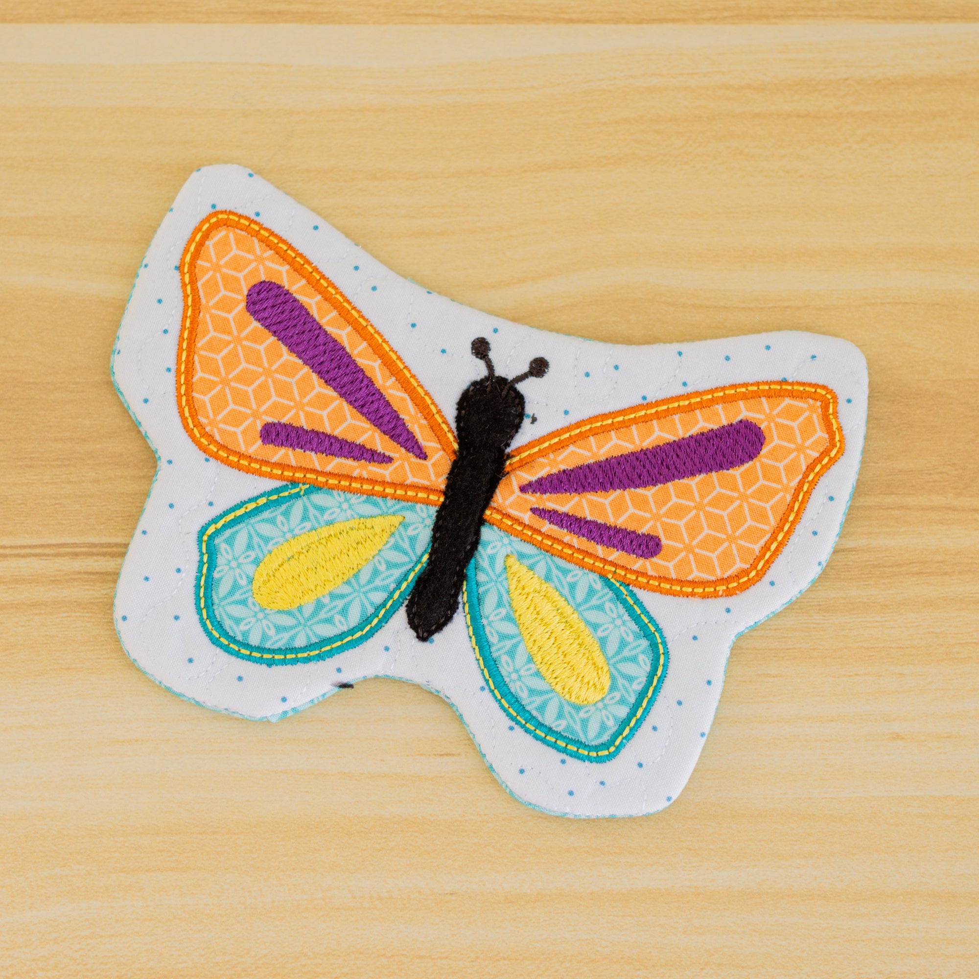 Colorful butterfly-shaped patch on a wooden surface