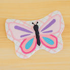 Butterfly-shaped fabric toy on a wooden surface