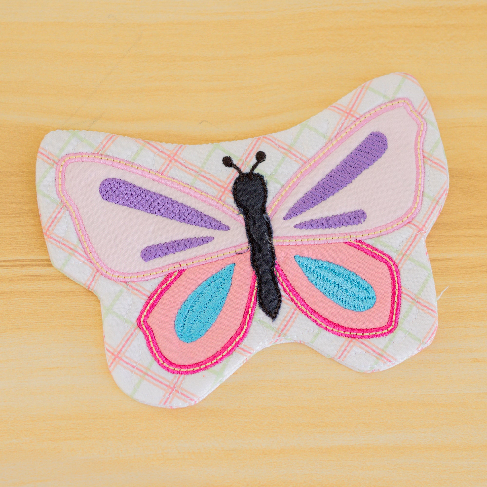 Butterfly-shaped fabric toy on a wooden surface