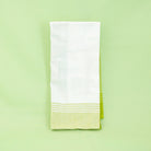 White towel with green hem on a light green background