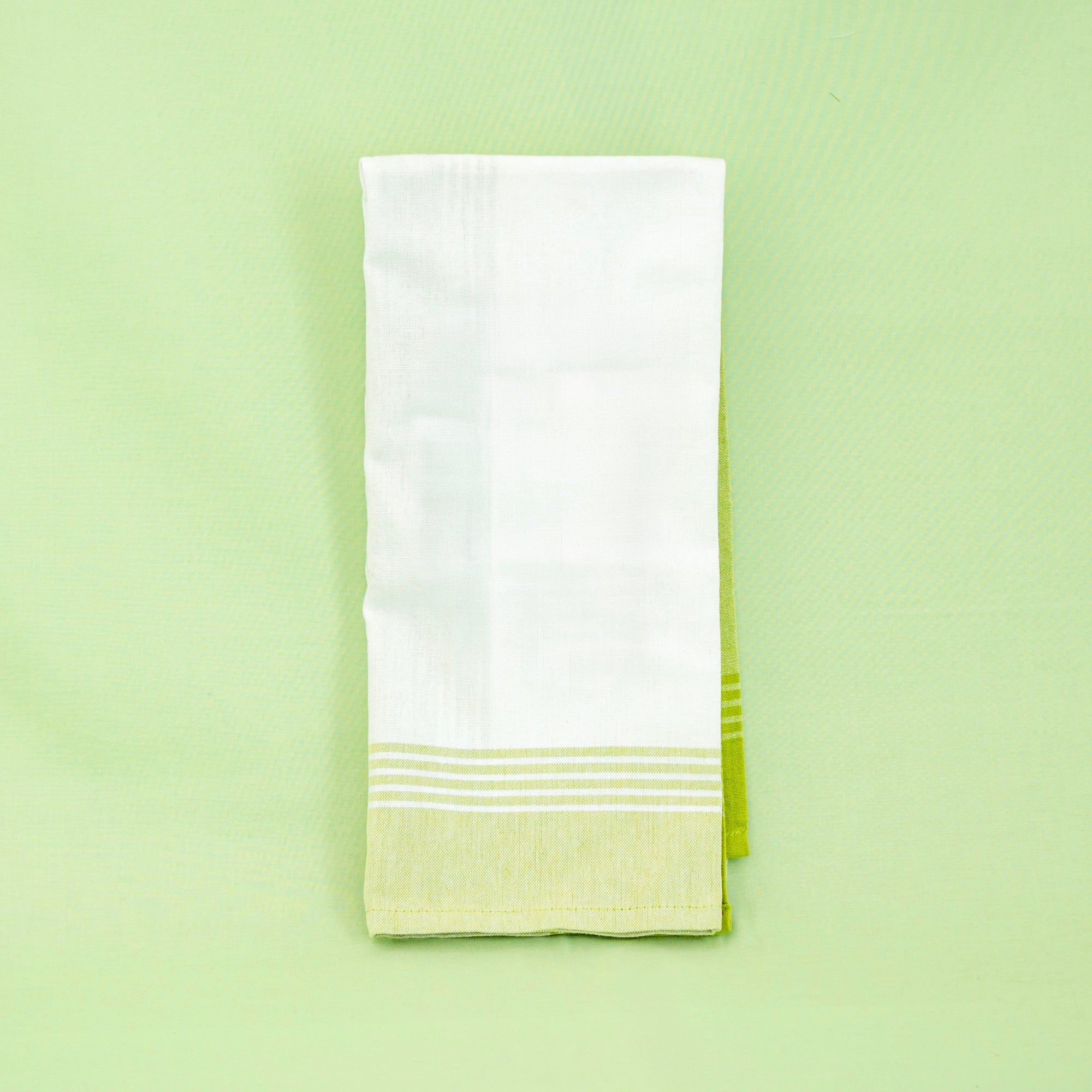 White towel with green hem on a light green background