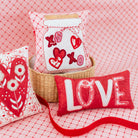 Decorative pillows with heart and 'LOVE' designs on a red checkered background
