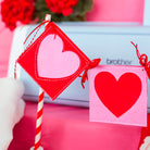 Heart-shaped flags on a spool with a pink background