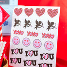 Sheet of stickers with hearts, cupids, and 'I LOVE YOU' text on a red background.