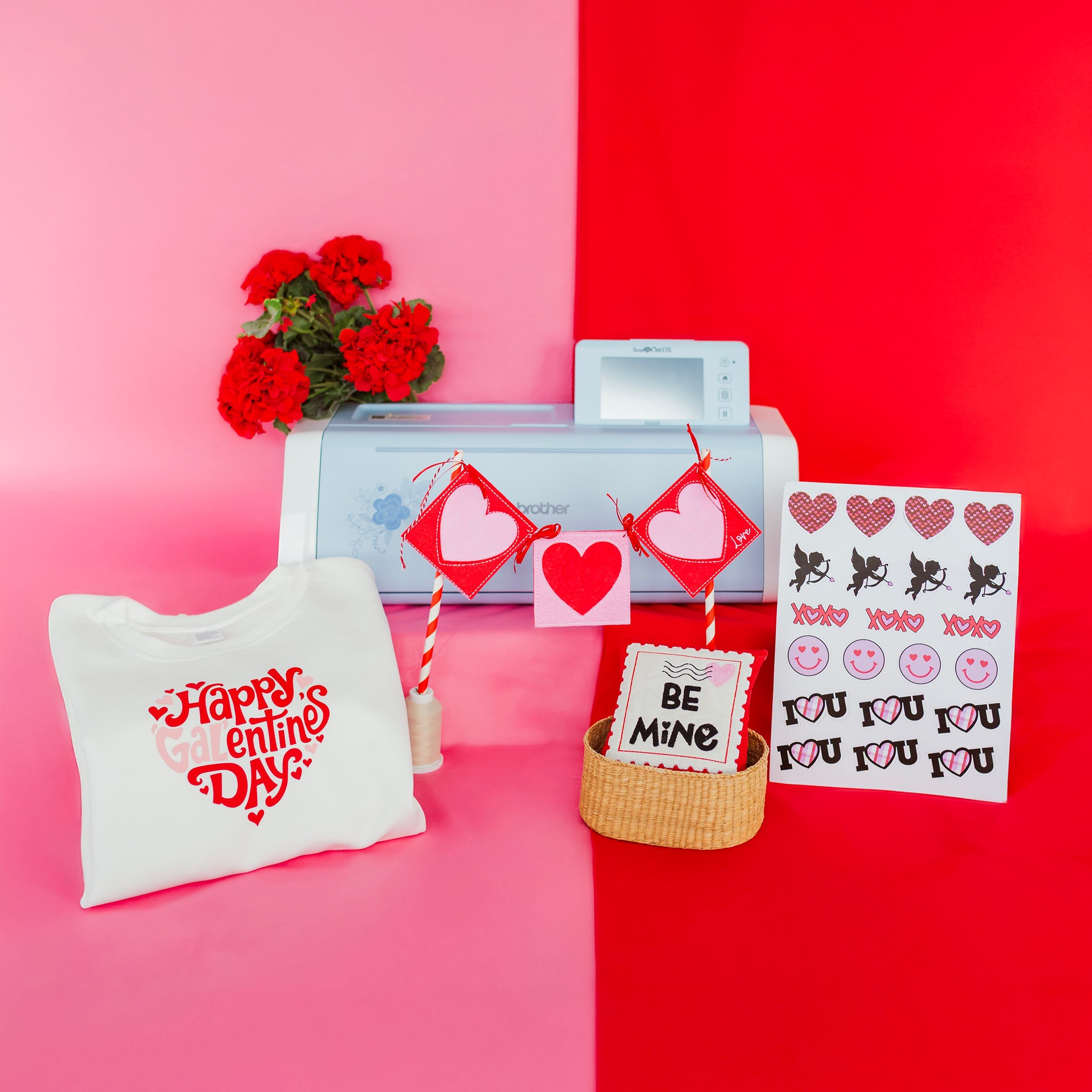 Valentine's Day-themed items including a white bag, printer, and decorative items on a pink and red background.