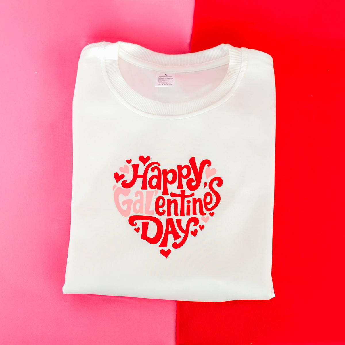 White t-shirt with 'Happy Valentine's Day' text on a pink and red gradient background