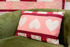 Patchwork pillow with heart designs on a green couch