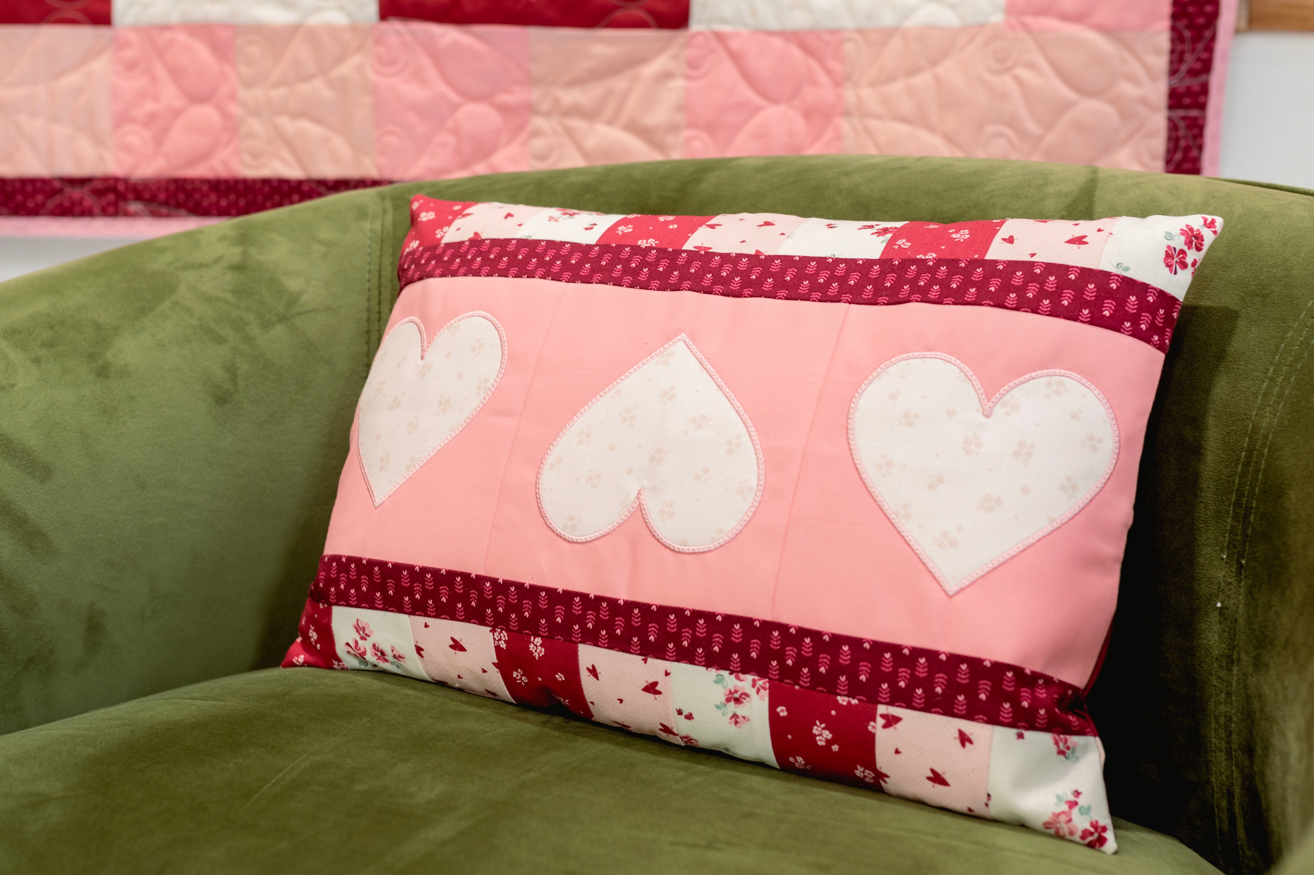 Patchwork pillow with heart designs on a green couch