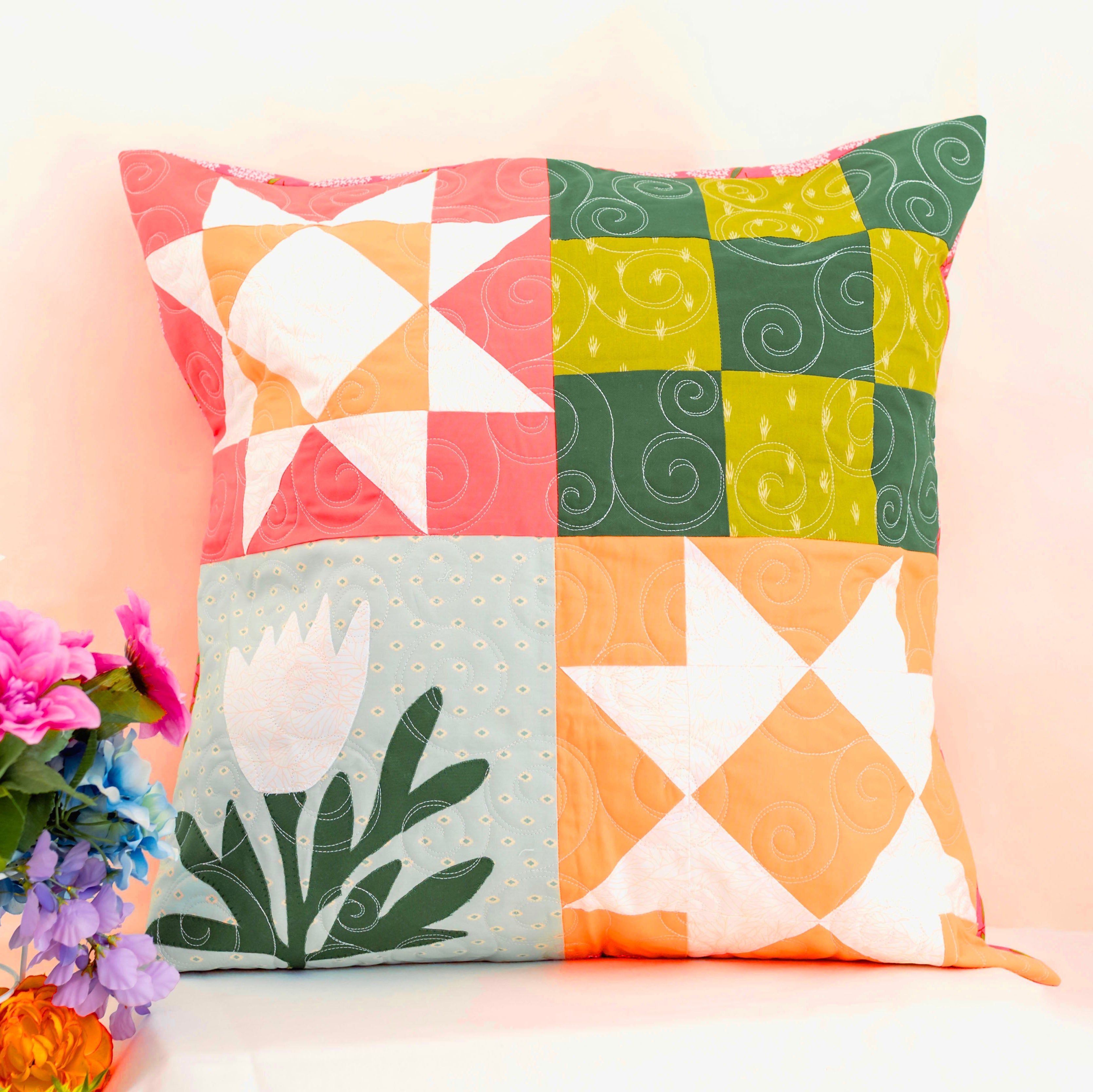 Colorful patchwork pillow with floral design on a light background