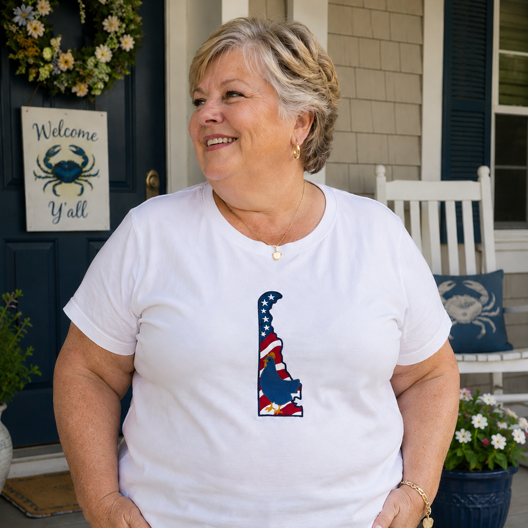 Woman wearing a white t-shirt with a graphic design on a porch.