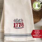 Towel with 'Est. 1776' embroidery design on a wooden surface