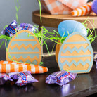 Decorative Easter egg-shaped candies with candy bars on a dark surface.
