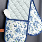 Set of floral oven mitts and pot holders on a dark surface