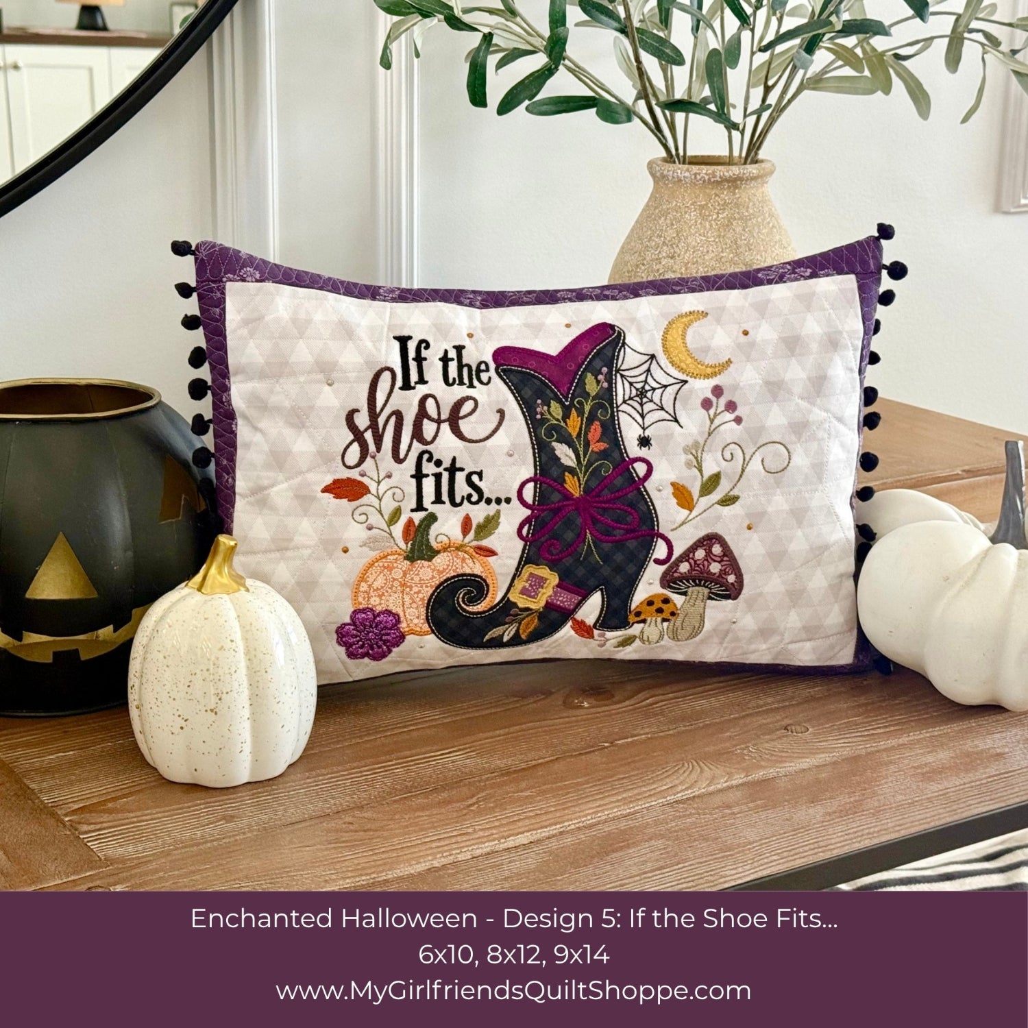 A decorative rectangular quilted pillow displayed on a wooden table in a styled home setting. The pillow features a Halloween-themed design with the text 'If the shoe fits.
